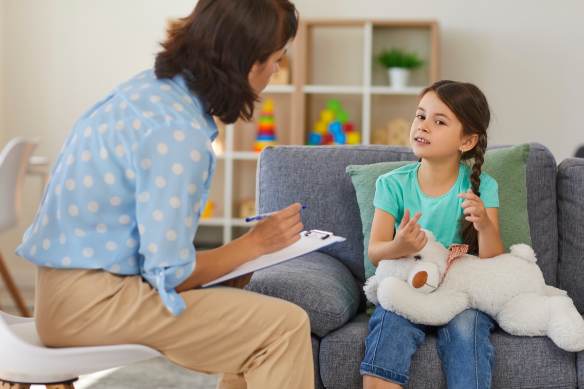 A psychologist listening to a child during a clinical session